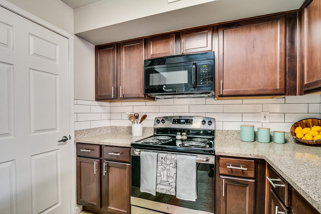 a kitchen with wood cabinets and black appliances