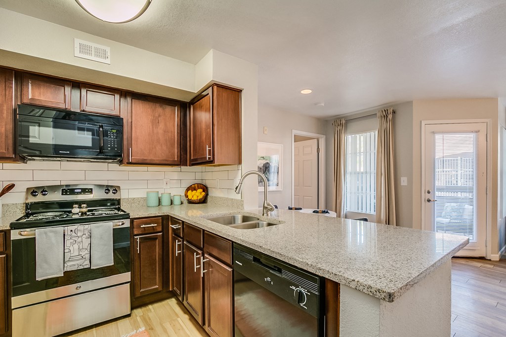a kitchen with wooden cabinets and a granite counter top