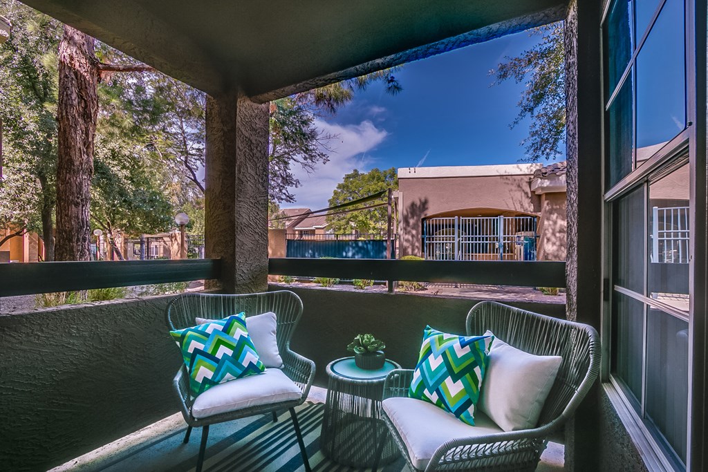 a balcony with two chairs and a table