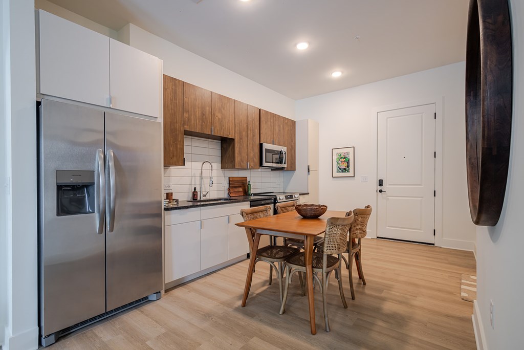 A modern kitchen with a wooden table and chairs.