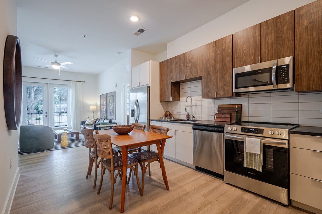 A modern kitchen with a wooden table and chairs.