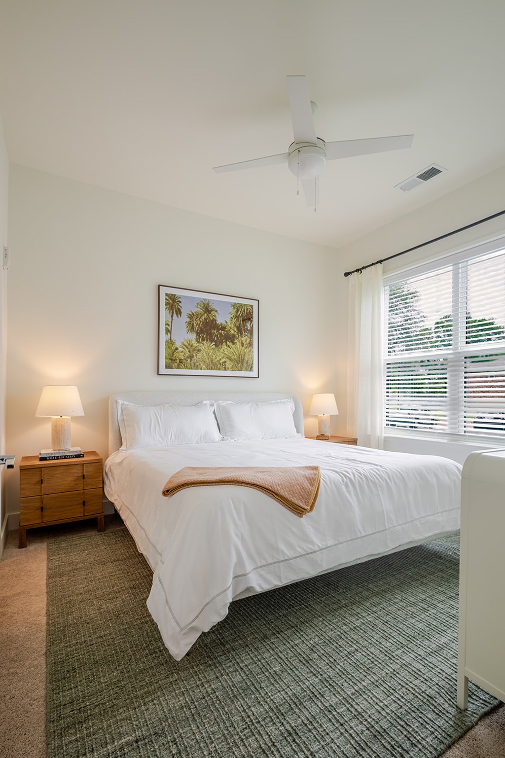 A bedroom with a large bed and a painting on the wall.