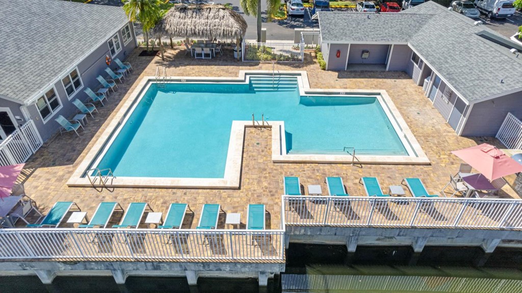 A large swimming pool surrounded by lounge chairs and umbrellas.