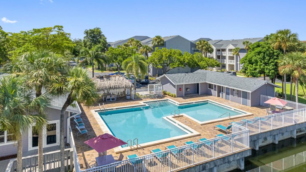 A pool surrounded by a fence and trees.