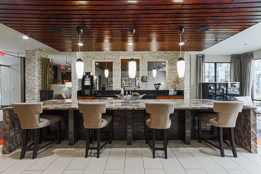 a kitchen with a bar and chairs and a living room