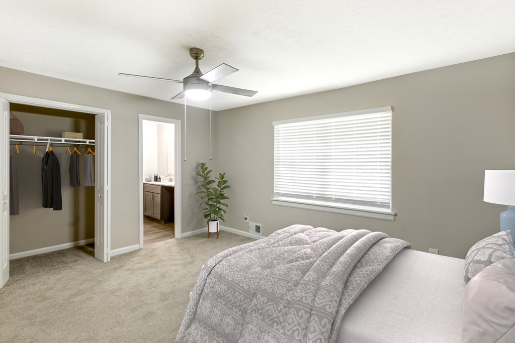 a bedroom with a large bed and a ceiling fan