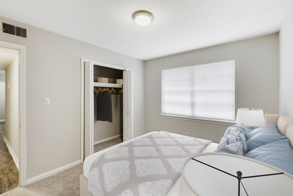 a bedroom with a bed and a closet with a window