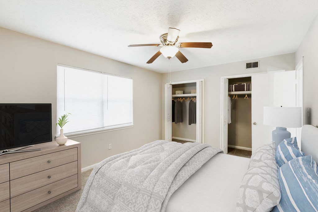 a bedroom with a bed and a ceiling fan
