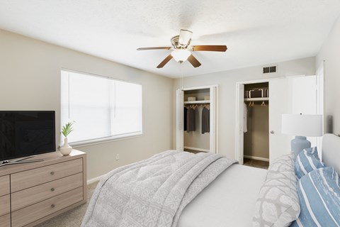 a bedroom with a bed and a ceiling fan