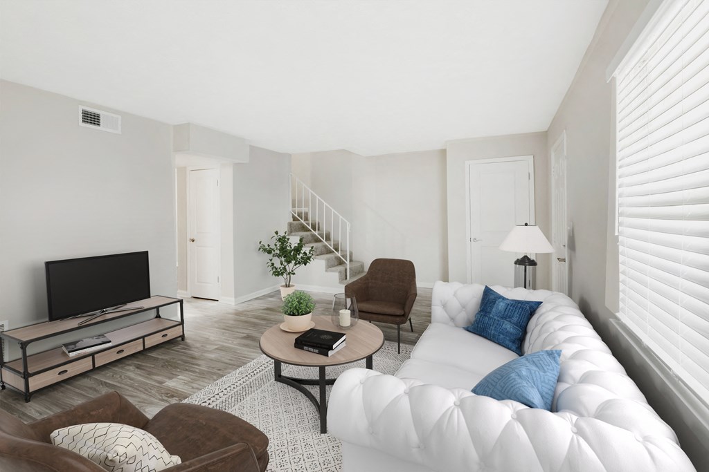 a living room with a white couch and a tv