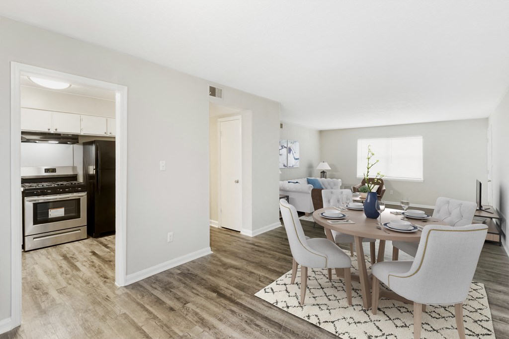 a living room and dining room with a table and chairs