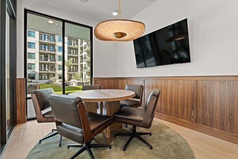 A modern dining room with a round table and chairs.