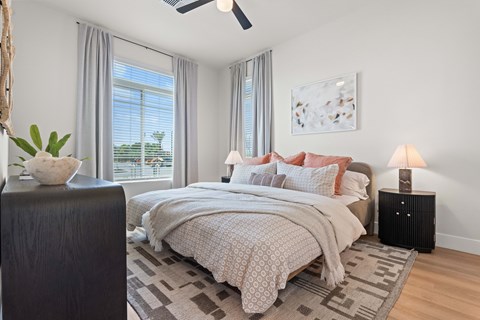 A bedroom with a large bed and a ceiling fan.