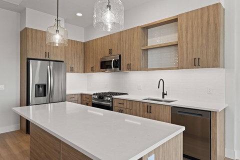 A modern kitchen with wooden cabinets and stainless steel appliances.