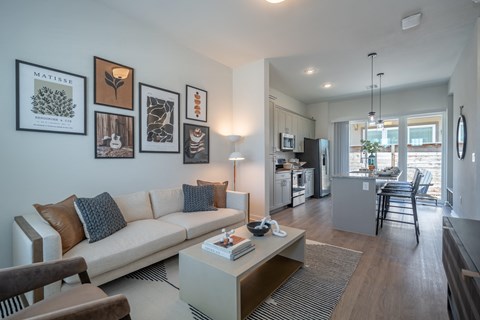 a living room with a couch and a coffee table and a kitchen