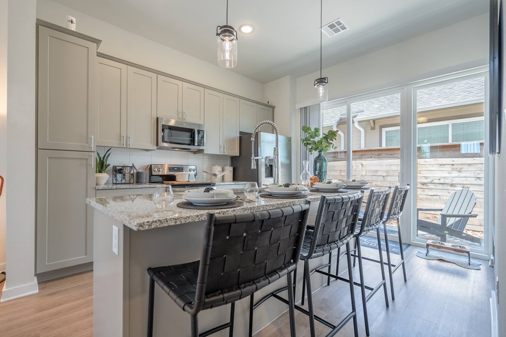 an open kitchen and dining area with a marble counter top