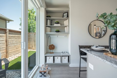 a kitchen with a sliding glass door to a backyard with a table and a counter