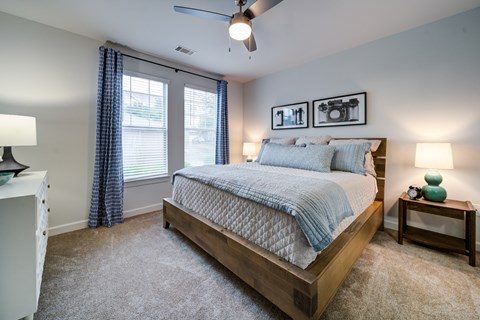 A bedroom with a large bed and a ceiling fan.