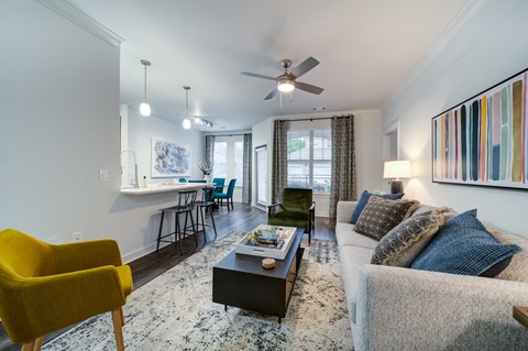 A living room with a yellow chair and a grey couch.