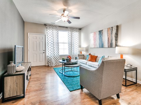 a living room with a ceiling fan and hardwood flooring