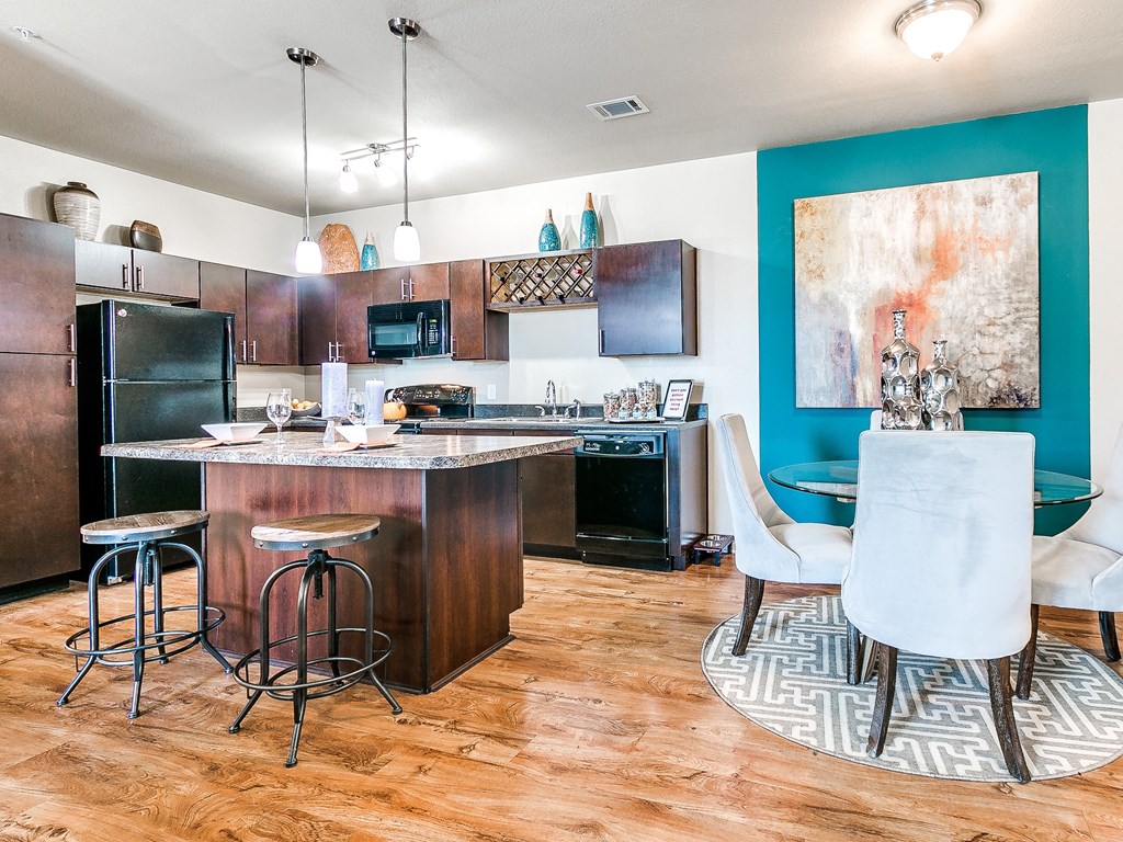 a kitchen and dining area with dark wood cabinets and a blue accent wall