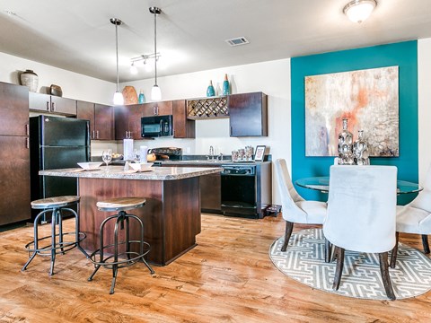 a kitchen and dining area with dark wood cabinets and a blue accent wall