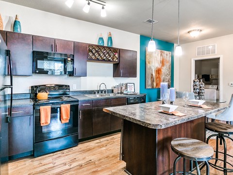 a kitchen with black appliances and a granite countertop