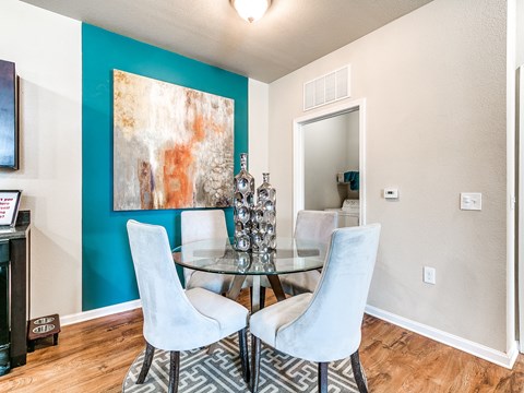 a dining room with a glass table and four chairs
