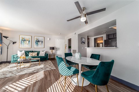 a living room with a table and chairs and a ceiling fan