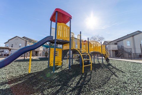 a playground with a swing set and slides in a yard