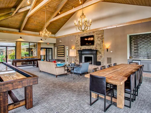 a large living room with a large wooden table and a fireplace
