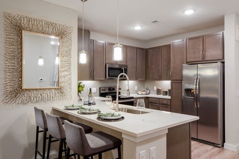 a kitchen with a large island and stainless steel refrigerator