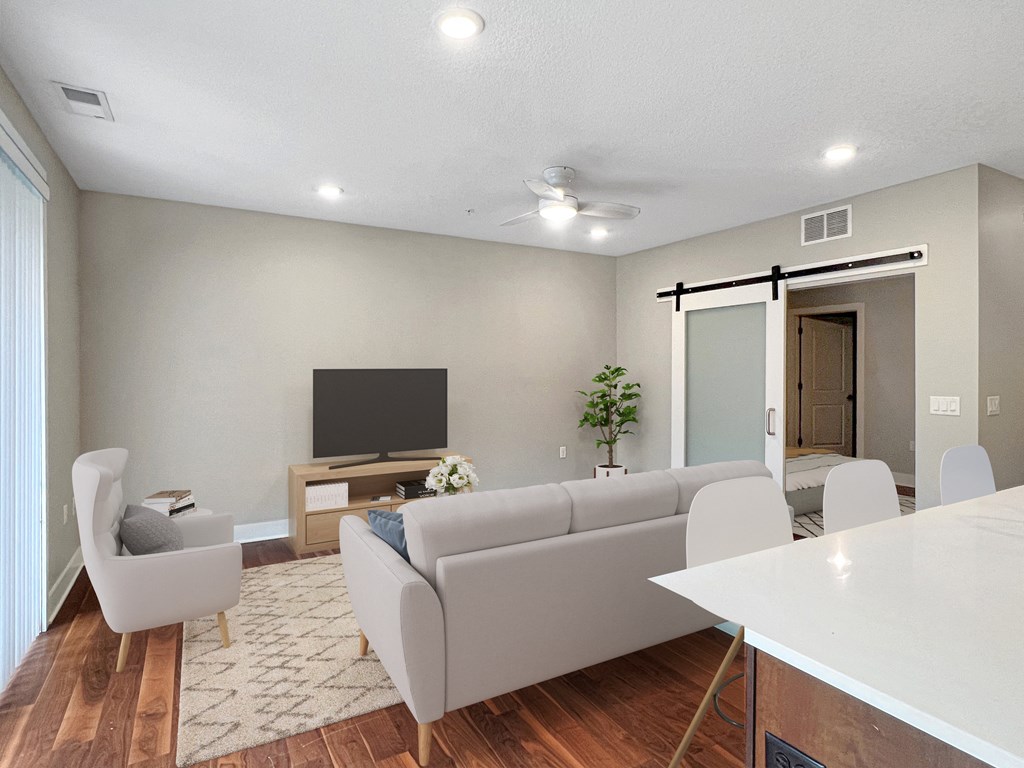 a living room with white couches and chairs and a television