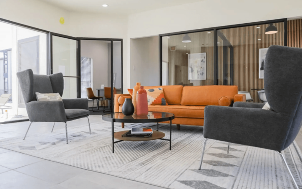 a living room with a orange couch and chairs