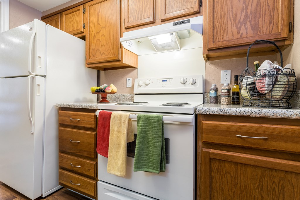 a kitchen with white appliances and wooden cabinets
