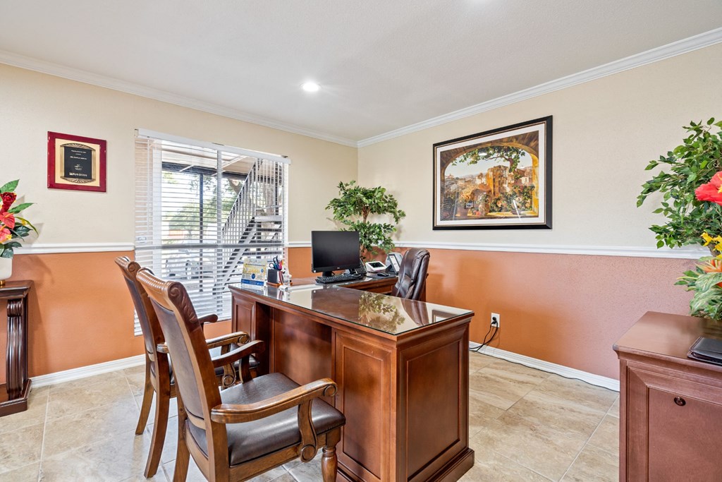 a desk with chairs in a room with a window