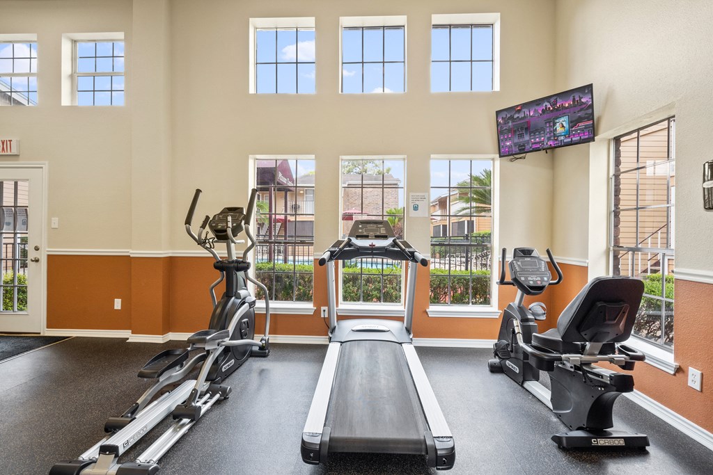 a gym with two treadmills and two ellipticals