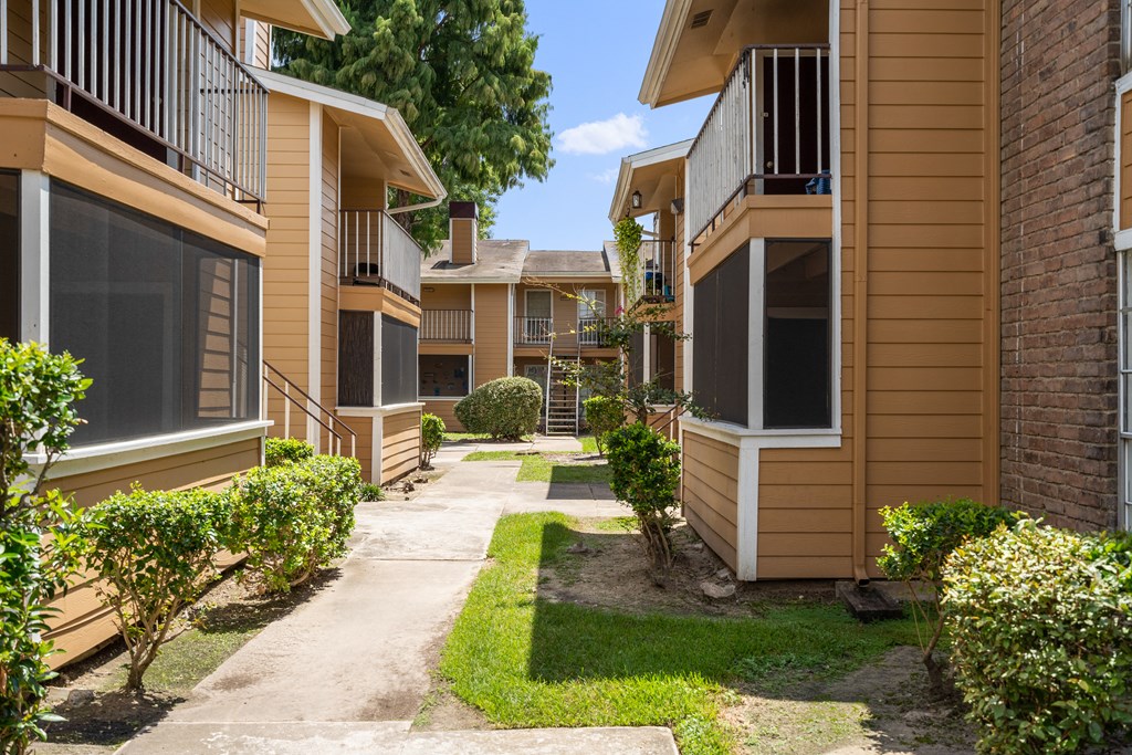 a pathway lined with yellow and brown condominiums