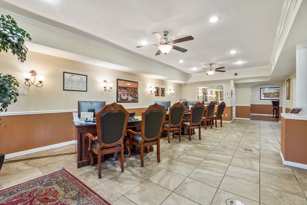 a room with a long table with chairs and a ceiling fan
