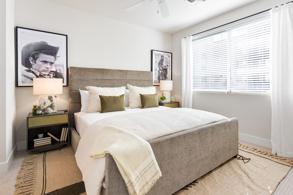 A bedroom with a large bed and a picture of a man on the wall.
