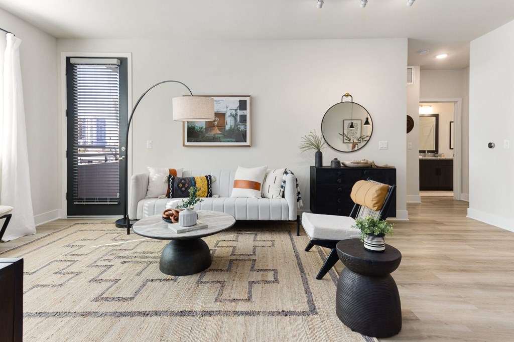 A living room with a white couch, a coffee table, and a rug.