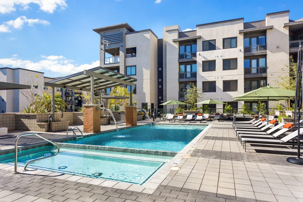 A swimming pool area in front of a modern building.