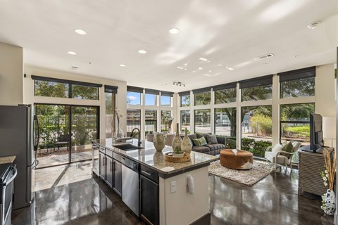 A modern kitchen with a large island and a view of the backyard.