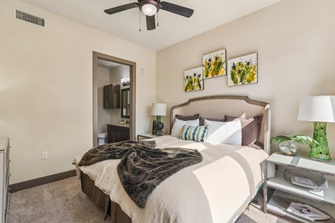 A bedroom with a large bed and a ceiling fan.