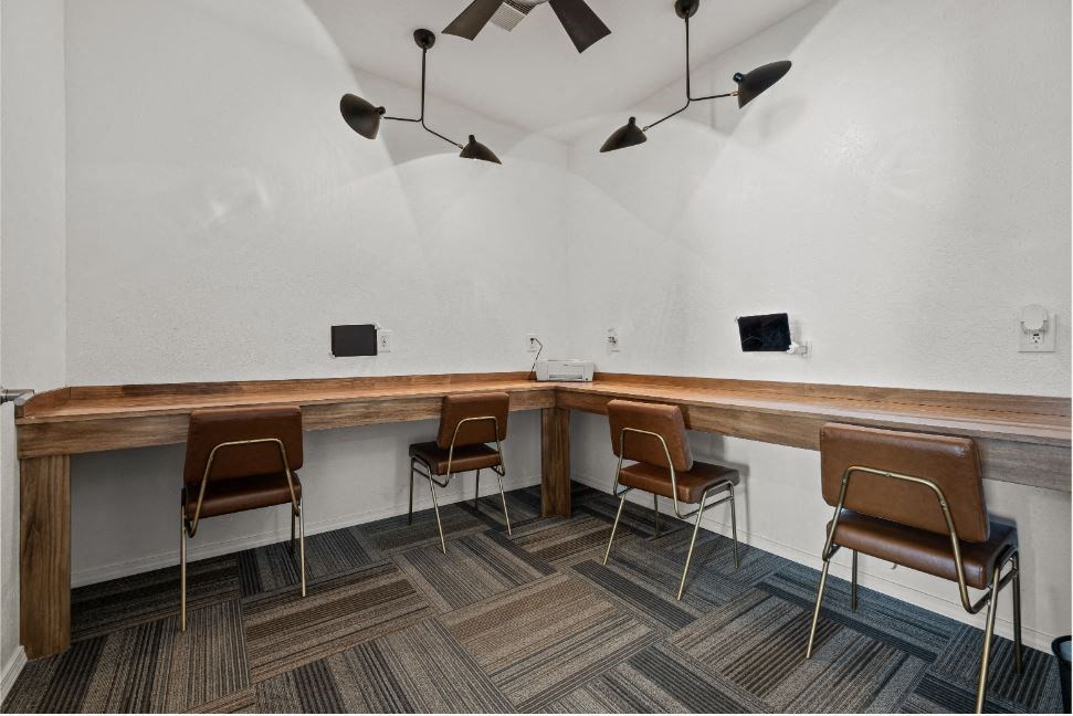 a long wooden table with chairs in a room