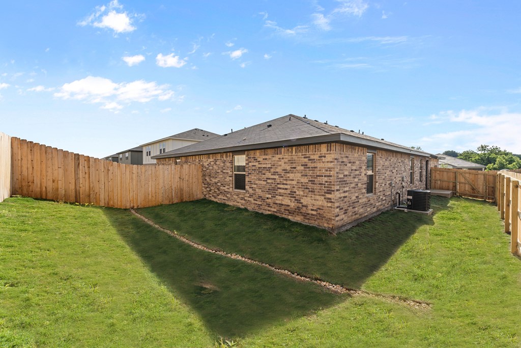 a backyard with a brick house and a wooden fence