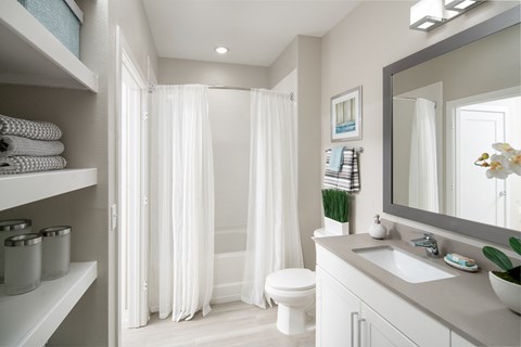A white bathroom with a toilet, sink, and shower.