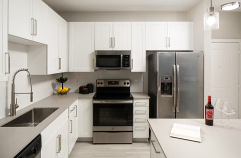 A modern kitchen with stainless steel appliances and white cabinets.