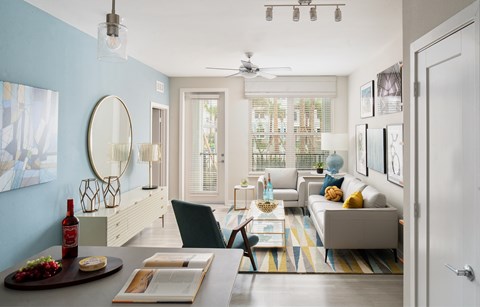 A dining table with a bottle of wine and a plate of food on it.