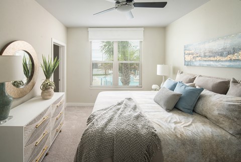 A bedroom with a large bed and a painting on the wall.